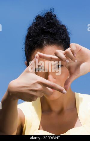 Portrait of a young woman making a finger frame in front of her face Stock Photo