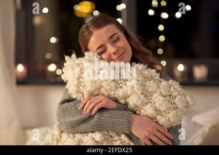 happy young woman with soft pillow in bed at home Stock Photo