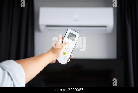 Hand with Remote control on off. Remote Control Directed on the Conditioner Stock Photo