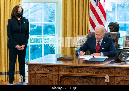 President Joe Biden, joined by Vice President Kamala Harris, signs two executive orders on healthcare Thursday, Jan. 28, 2021, in the Oval Office of the White House. Stock Photo