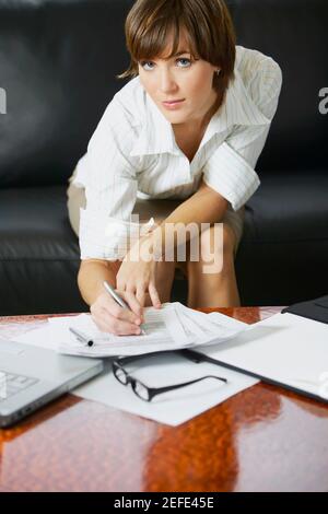 Portrait of a businesswoman signing documents on the table Stock Photo