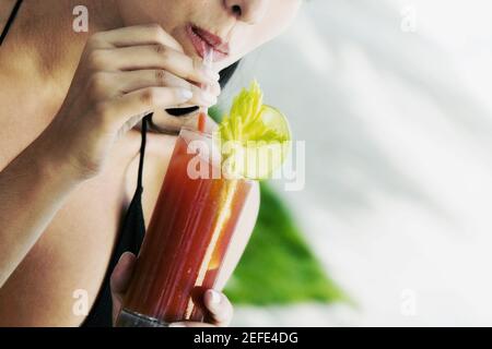 Close-up of a young woman drinking a bloody mary Stock Photo