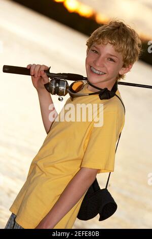 Close-up of a teenage boy holding a fishing rod - Stock Photo