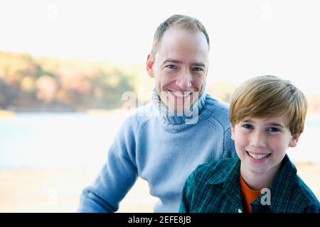 Portrait of a mid adult man with his son smiling Stock Photo