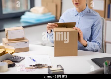 woman packing parcel box at post office Stock Photo