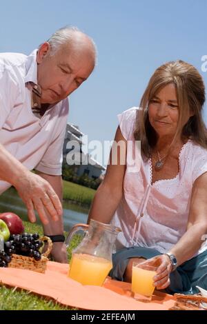 Senior couple enjoying juice at picnic Stock Photo