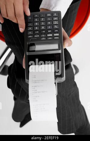 Mid section view of a businesswoman holding an adding machine tape Stock Photo