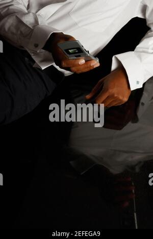 Mid section view of a person using a mobile phone Stock Photo