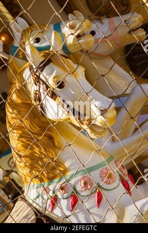 Chain link fence in front of carousel horses, Bordeaux, Aquitaine, France Stock Photo