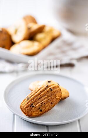 Madeleine with chocolate. Traditional French small cakes on plate. Stock Photo