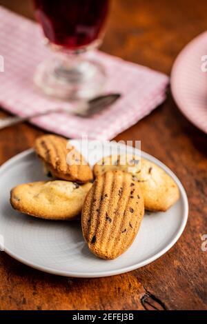 Madeleine with chocolate. Traditional French small cakes on plate. Stock Photo