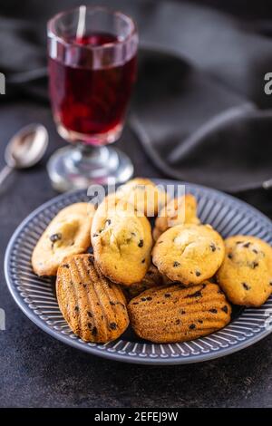 Madeleine with chocolate. Traditional French small cakes on plate. Stock Photo