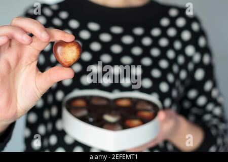 Midsection of woman holding valentines chocolate Stock Photo