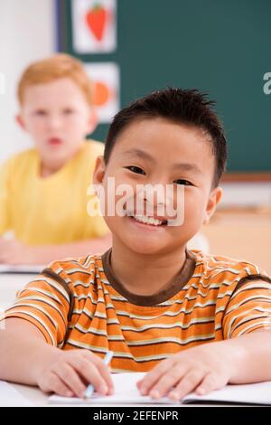 Portrait of a boy smiling in a classroom Stock Photo