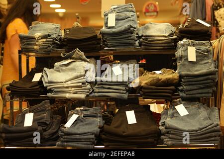 Denim pants folded on display at shopping mall. Stock Photo