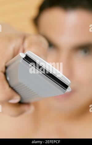 Close-up of a personÅ½s hand holding a remote control Stock Photo