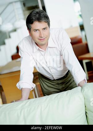 Portrait of a mature man leaning over a couch and smiling Stock Photo