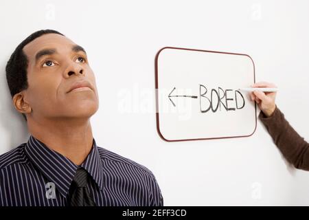 Businessman thinking with a businesswomanÅ½s hand writing on the whiteboard Stock Photo