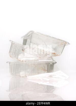 Used food trays shot on a white background with reflection, many council home collection recycle bins can not process plastic food trays . Stock Photo