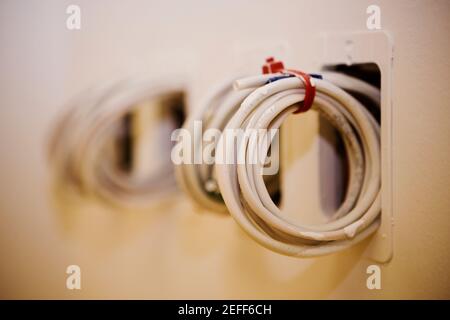 Close-up of a roll of cables coming out from a wall Stock Photo