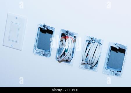 Close-up of a roll of cables coming out from a wall Stock Photo