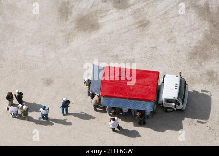 High angle view of construction workers standing near a semi truck Stock Photo