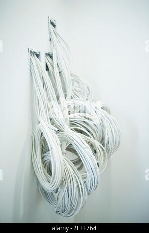 Close-up of a roll of cables coming out from a wall Stock Photo