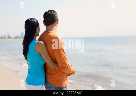 Side profile of a young man embracing a teenage girl from behind Stock ...