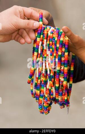 Close-up of two peopleÅ½s hands holding necklaces Stock Photo