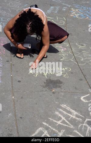 High angle view of a gay man writing a message with a chalk on the road Stock Photo