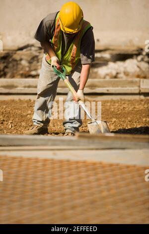 Construction worker using a shovel at a construction site Stock Photo