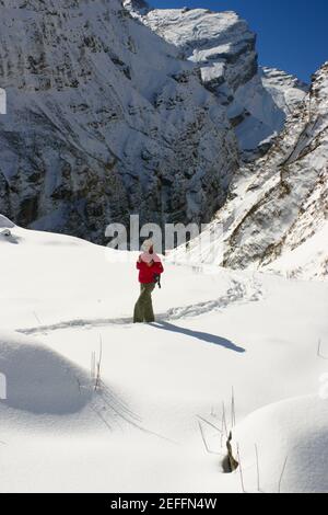 Male hiker walking in a snow covered landscape, Annapurna Range, Himalayas, Nepal Stock Photo