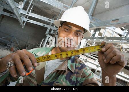 Portrait of a male construction worker holding a tape measure Stock Photo