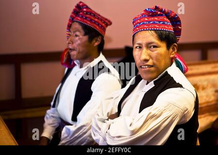 Close-up of two young men taking part in a wedding ceremony, Taquile Island, Lake Titicaca, Puno, Peru Stock Photo