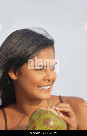 Close up of a young woman holding a coconut Stock Photo