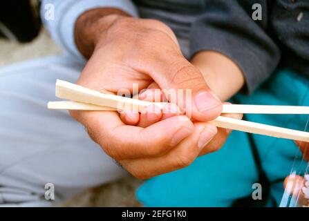 Close-up of a father teaching his son the use of chopsticks, Okinawa, Japan Stock Photo