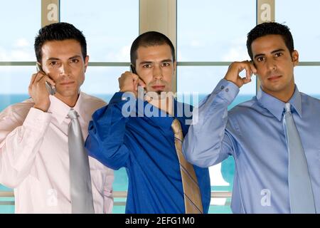 Portrait of three businessmen using mobile phones Stock Photo