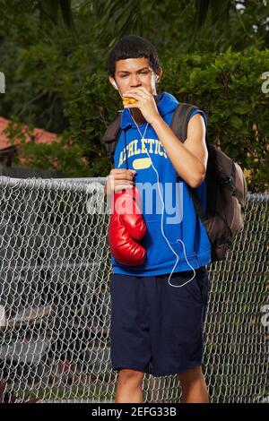 Teenage boy listening an ipod and eating empanada Stock Photo