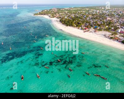 Top View on Traditional African Wooden Dhow Boats on Clean Turquoise Water near the Coast of Zanzibar at Nungwi Beach. Aerial Shot Stock Photo