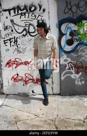 Young man leaning against a wall Stock Photo