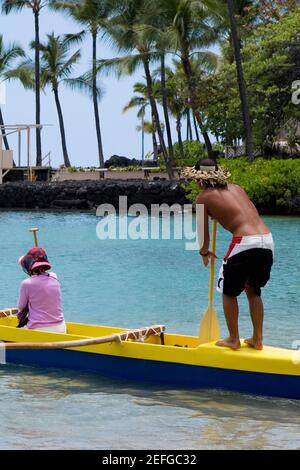 Rear view of a man and a woman canoeing in the sea, Captain CookÅ½s Monument, Kealakekua Bay, Kona Coast, Big Island, Hawaii islands, USA Stock Photo