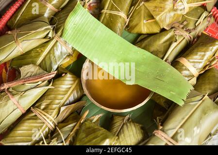 Guwahati, Assam, India. 17th Feb, 2021. Traditional rice beer and rice wraping with banana leafs, during Ali-Aye-Ligang festival in Guwahati, India on 17 February 2021. Ali-Aye-Ligang, the main harvest festival of the ethnic Mising community people, this spring festival associated with agriculture, especially with the beginning of the Ahu paddy cultivation. Credit: David Talukdar/ZUMA Wire/Alamy Live News Stock Photo