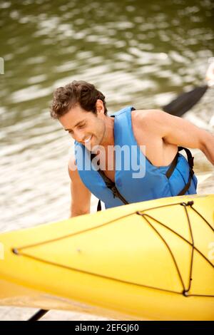 High angle view of a mid adult man carrying a kayak and an oar Stock Photo