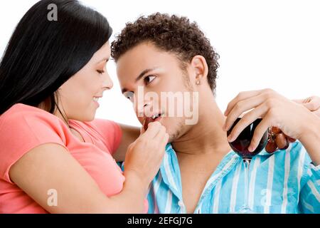 Portrait of a young woman feeding grapes to a young man Stock Photo