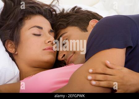 Close-up of a young couple sleeping on a bed Stock Photo