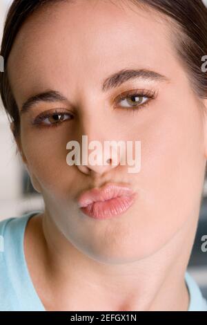 Close-up of a young woman puckering her lips Stock Photo