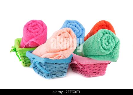 Rolled colorful towels in bamboo baskets isolated on white background. Stock Photo