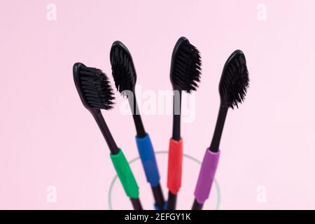 Eco toothbrushes made of bio degradable plastic and bamboo active charcoal on light pink background Stock Photo