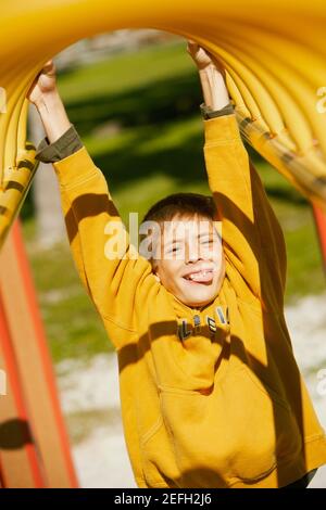 Close up of a boy hanging on a jungle gym Stock Photo