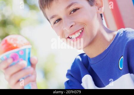 Portrait of a teenage boy smiling and holding an ice cream cone Stock Photo